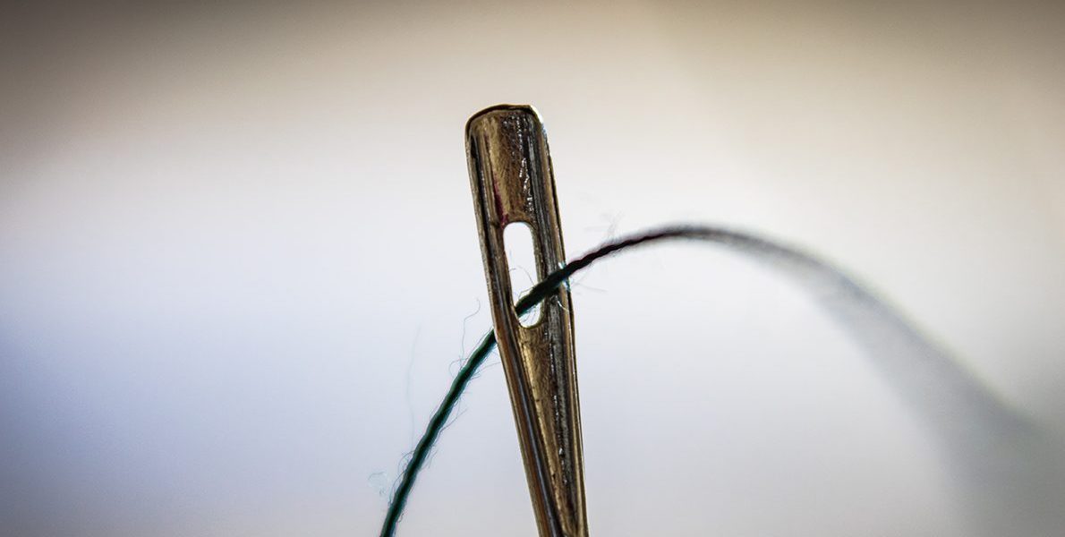 Grøn tråd gennem en nål
