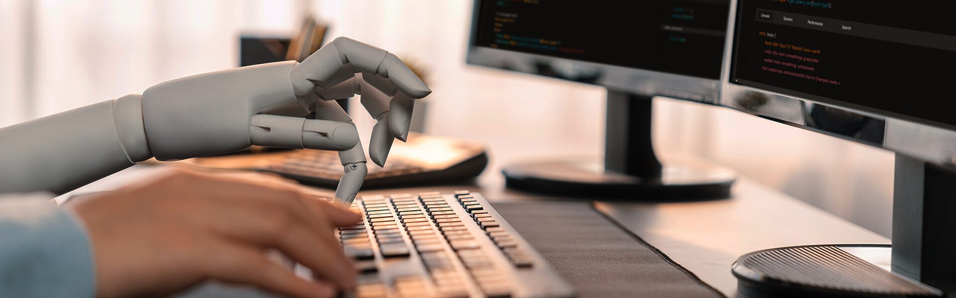 Billede af robot- og menneskehånd der koder